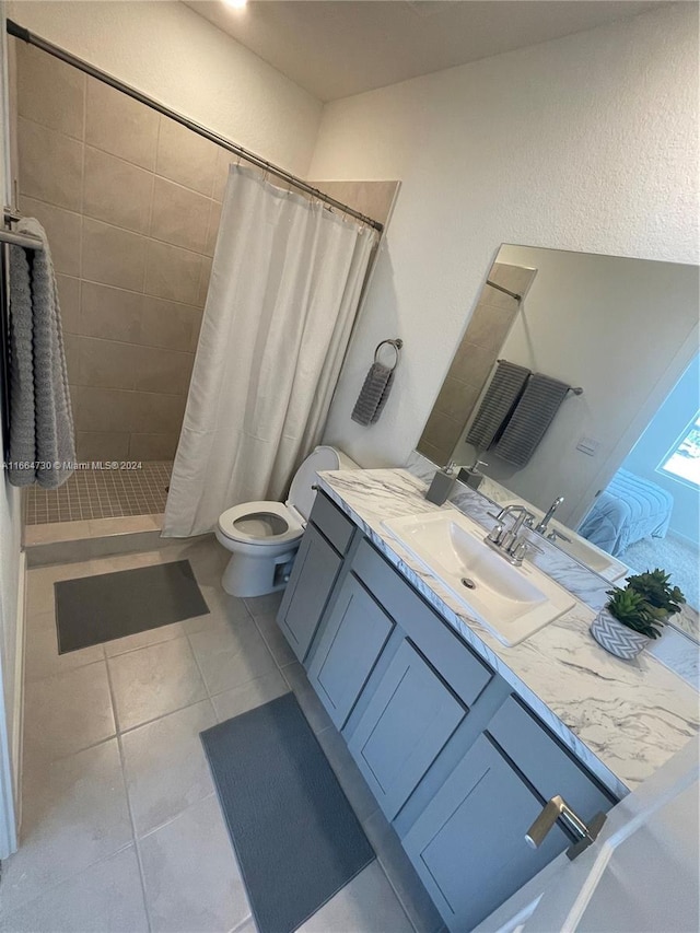 bathroom with tile patterned flooring, a shower with curtain, vanity, and toilet