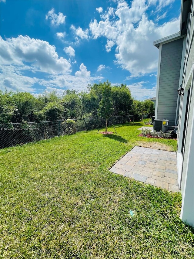 view of yard featuring a patio area and central air condition unit