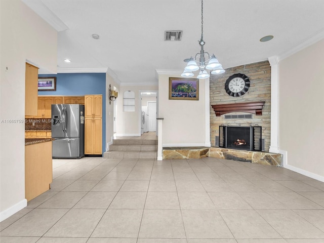 unfurnished living room featuring light tile patterned floors, a stone fireplace, ornamental molding, and a chandelier