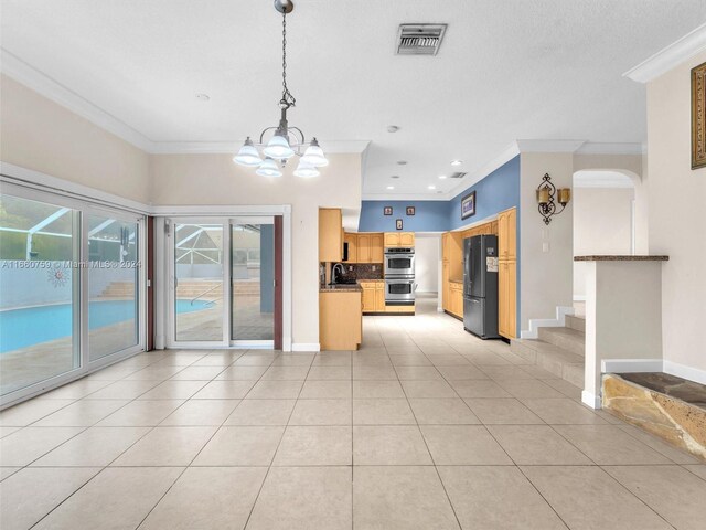 kitchen with ornamental molding, sink, stainless steel double oven, and black refrigerator