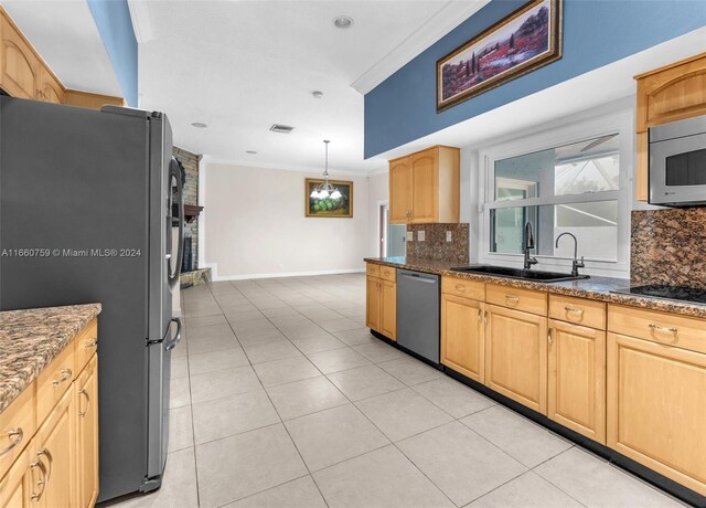 kitchen with sink, appliances with stainless steel finishes, ornamental molding, and tasteful backsplash