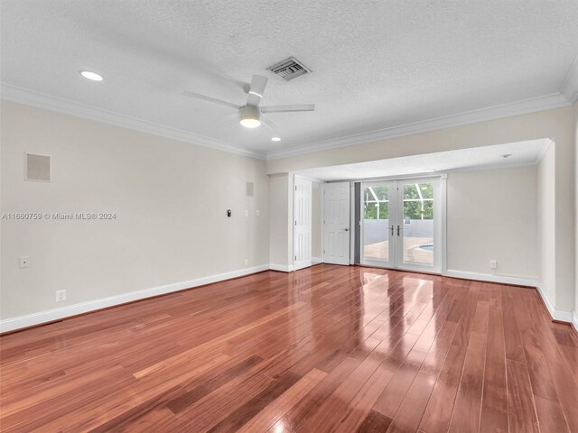 spare room featuring a textured ceiling, ceiling fan, french doors, hardwood / wood-style flooring, and ornamental molding