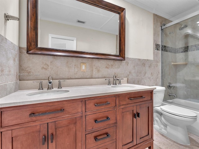 full bathroom featuring tiled shower / bath, vanity, tile walls, and toilet