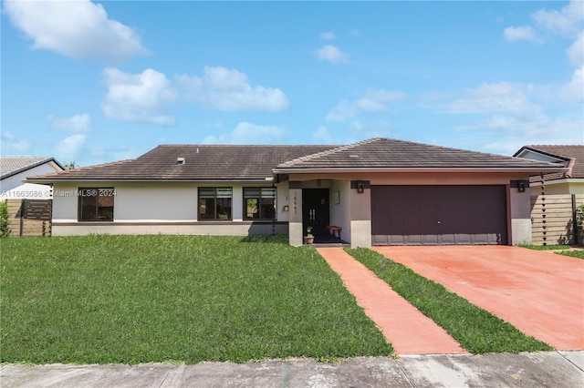 view of front of home featuring a front yard and a garage