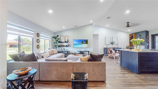 living room with wood-type flooring, vaulted ceiling, and ceiling fan