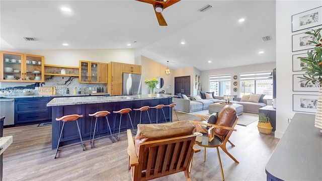 dining room featuring vaulted ceiling, ceiling fan, and light hardwood / wood-style flooring