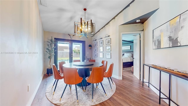 dining area with french doors, an inviting chandelier, and hardwood / wood-style floors