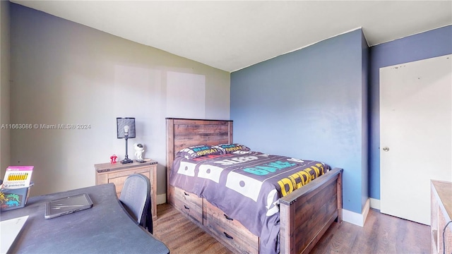 bedroom with vaulted ceiling and dark wood-type flooring