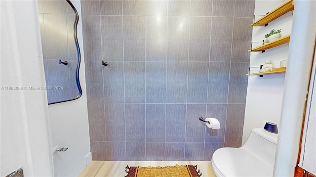 bathroom featuring tile walls and toilet