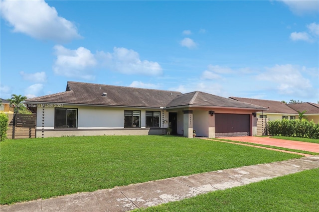 ranch-style home featuring a garage and a front lawn