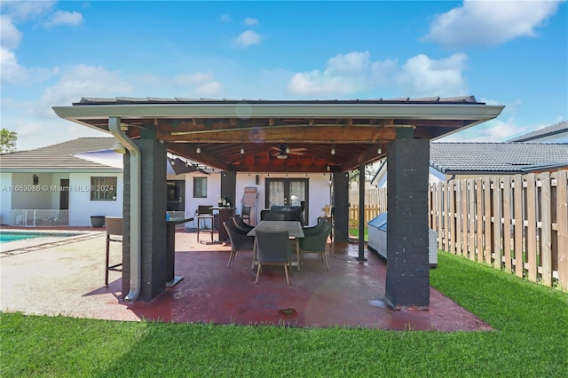 view of patio with a fenced in pool and ceiling fan