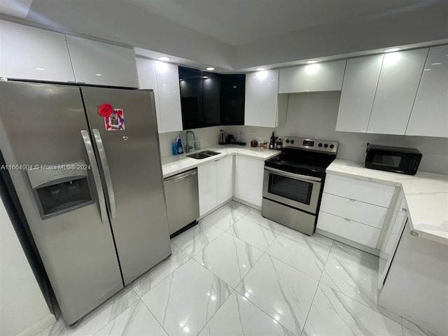 kitchen featuring stainless steel appliances, white cabinets, and sink