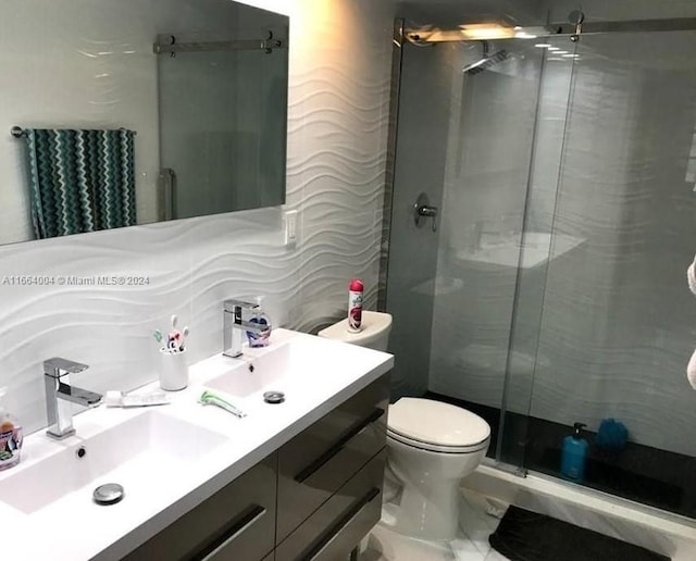 bathroom featuring an enclosed shower, vanity, and toilet