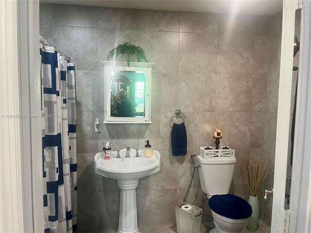 bathroom with walk in shower, tile walls, and toilet