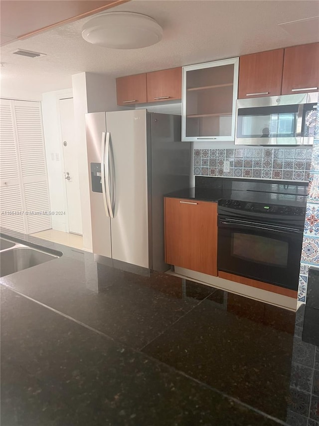 kitchen featuring black appliances and backsplash