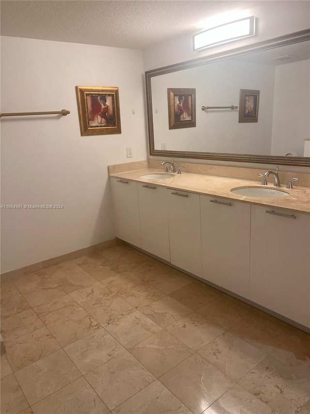 bathroom featuring a textured ceiling and vanity