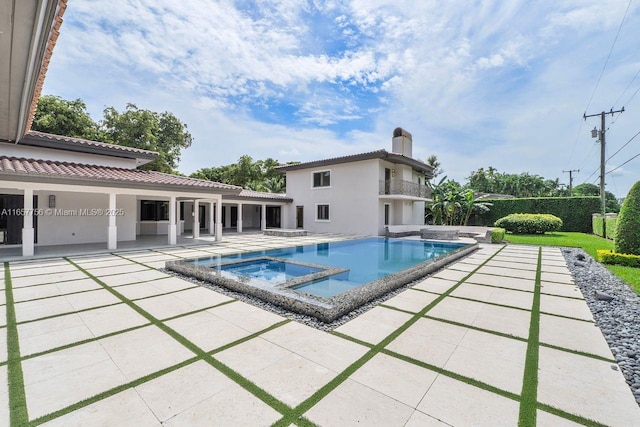 view of pool with a patio and a pool with connected hot tub