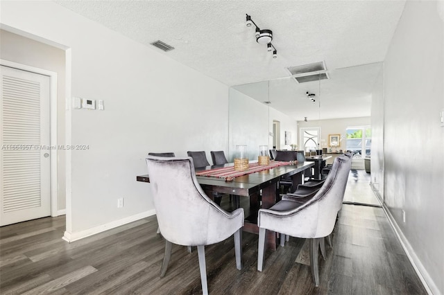 dining space featuring a textured ceiling and dark hardwood / wood-style flooring