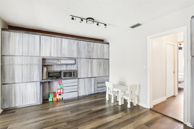 interior space featuring track lighting, a textured ceiling, and dark wood-type flooring