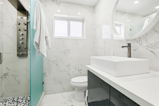 bathroom with tile walls, a shower with door, vanity, and toilet