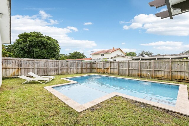 view of swimming pool featuring a yard