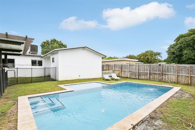 view of swimming pool with cooling unit, a yard, and pool water feature