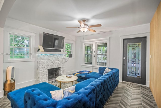 living room featuring parquet flooring, a stone fireplace, and ceiling fan