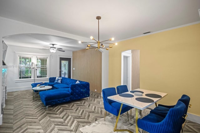 dining room with ceiling fan, crown molding, and parquet floors