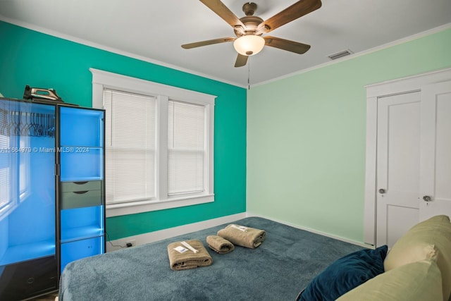 bedroom with carpet, ceiling fan, and crown molding