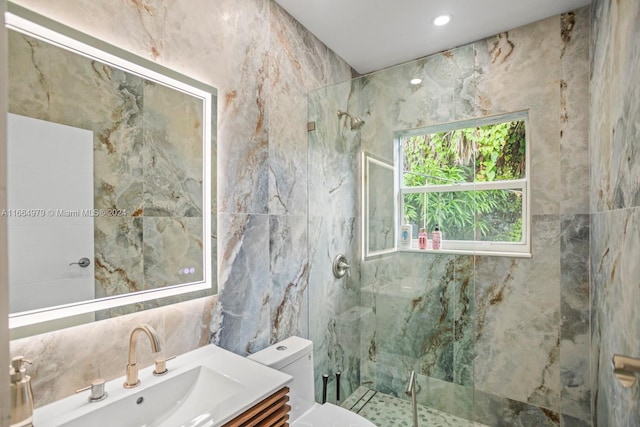 bathroom featuring vanity, tile walls, a shower with shower door, and toilet