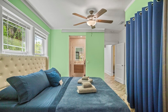 bedroom with light parquet flooring, crown molding, ceiling fan, and ensuite bathroom