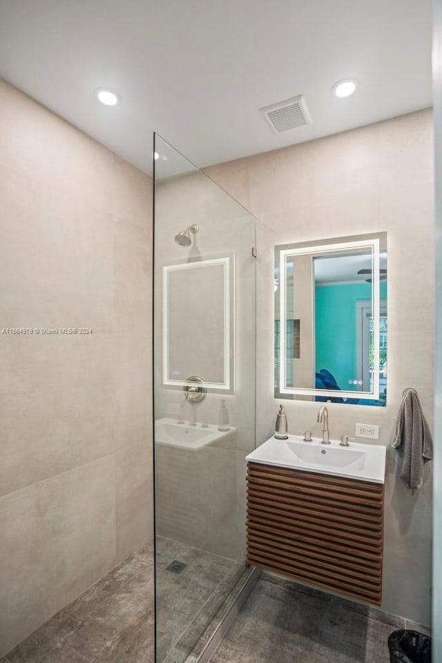 bathroom featuring vanity and tiled shower