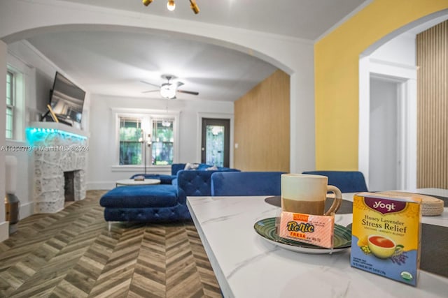 living room featuring ceiling fan and crown molding