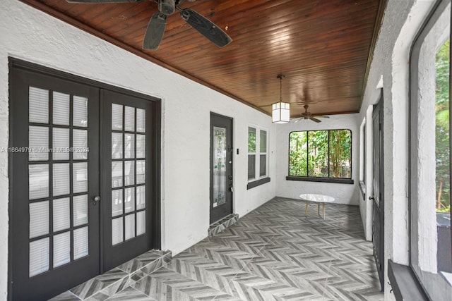 unfurnished sunroom with ceiling fan, wooden ceiling, and french doors