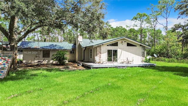 rear view of house with a yard and a deck