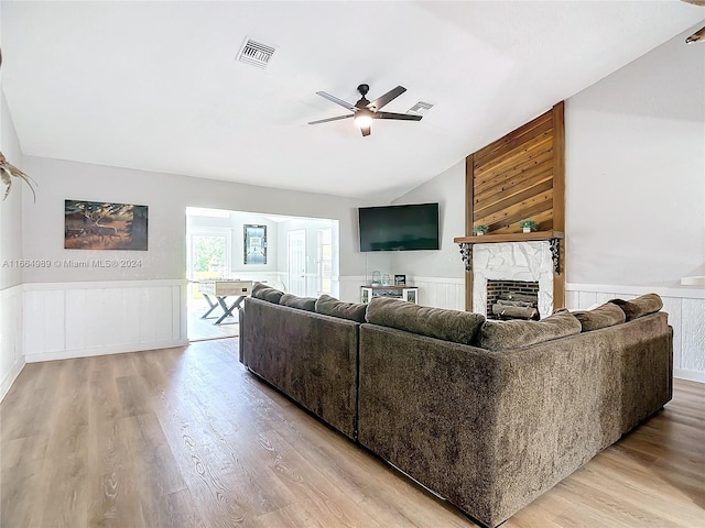 living room with a large fireplace, light hardwood / wood-style floors, and ceiling fan