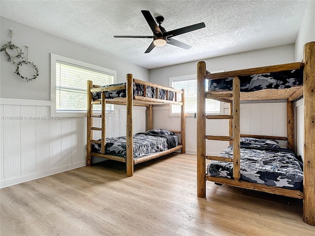 bedroom with light hardwood / wood-style floors, multiple windows, and ceiling fan