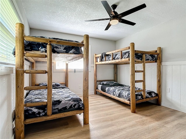 bedroom with multiple windows, a textured ceiling, and ceiling fan