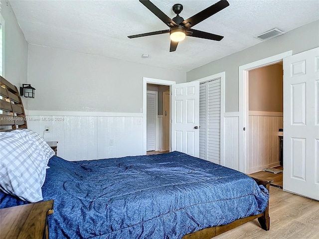 bedroom featuring a textured ceiling, light hardwood / wood-style floors, and ceiling fan