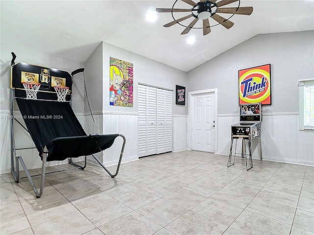 interior space with ceiling fan, lofted ceiling, and light tile patterned floors