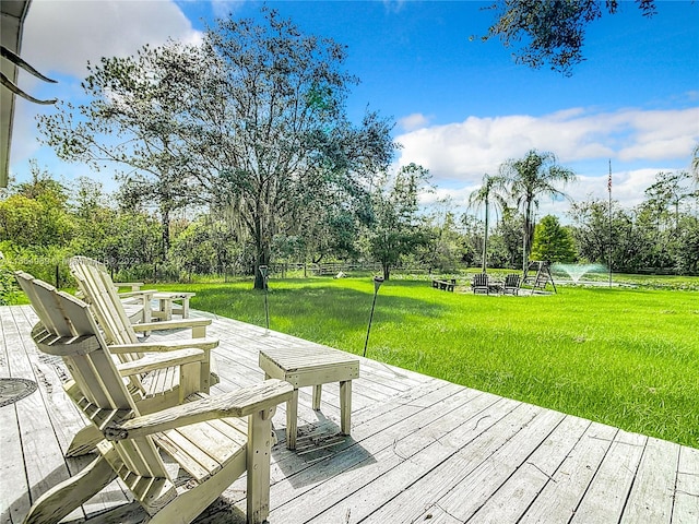 wooden terrace with a water view and a yard