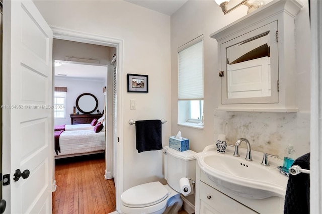 bathroom with vanity, hardwood / wood-style floors, toilet, and a healthy amount of sunlight