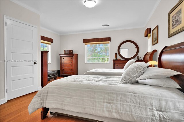 bedroom featuring hardwood / wood-style flooring, a chandelier, and ornamental molding