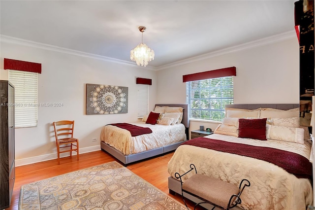 bedroom featuring ornamental molding, a notable chandelier, and hardwood / wood-style floors