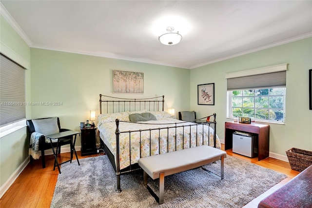 bedroom with light hardwood / wood-style floors and crown molding