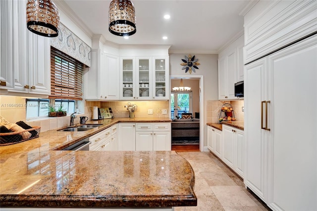 kitchen featuring crown molding, paneled built in fridge, and white cabinetry