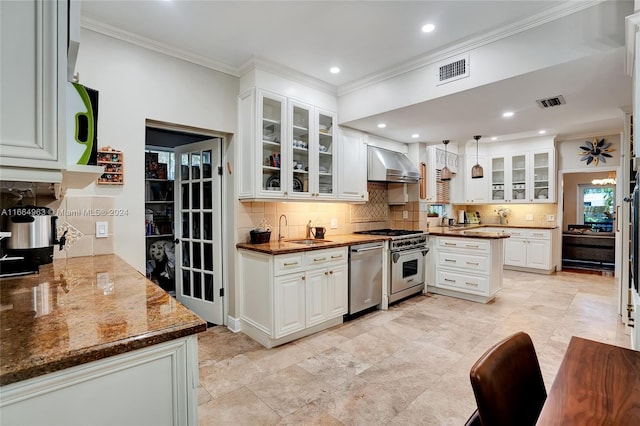 kitchen with wall chimney exhaust hood, hanging light fixtures, stainless steel appliances, and white cabinetry