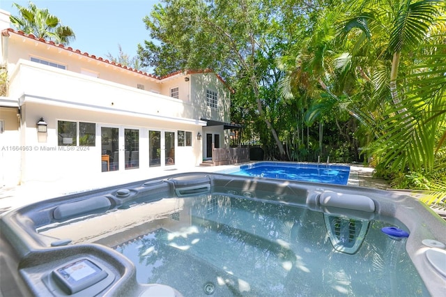 view of swimming pool with a hot tub