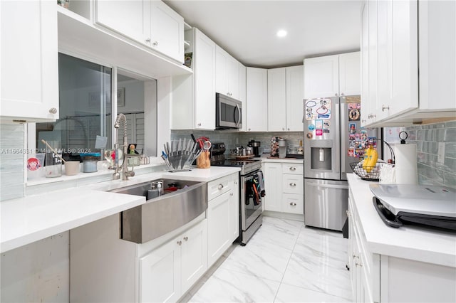 kitchen featuring stainless steel appliances, white cabinetry, tasteful backsplash, and sink