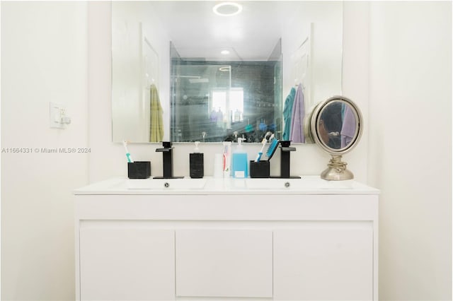 bathroom featuring a shower with door and vanity